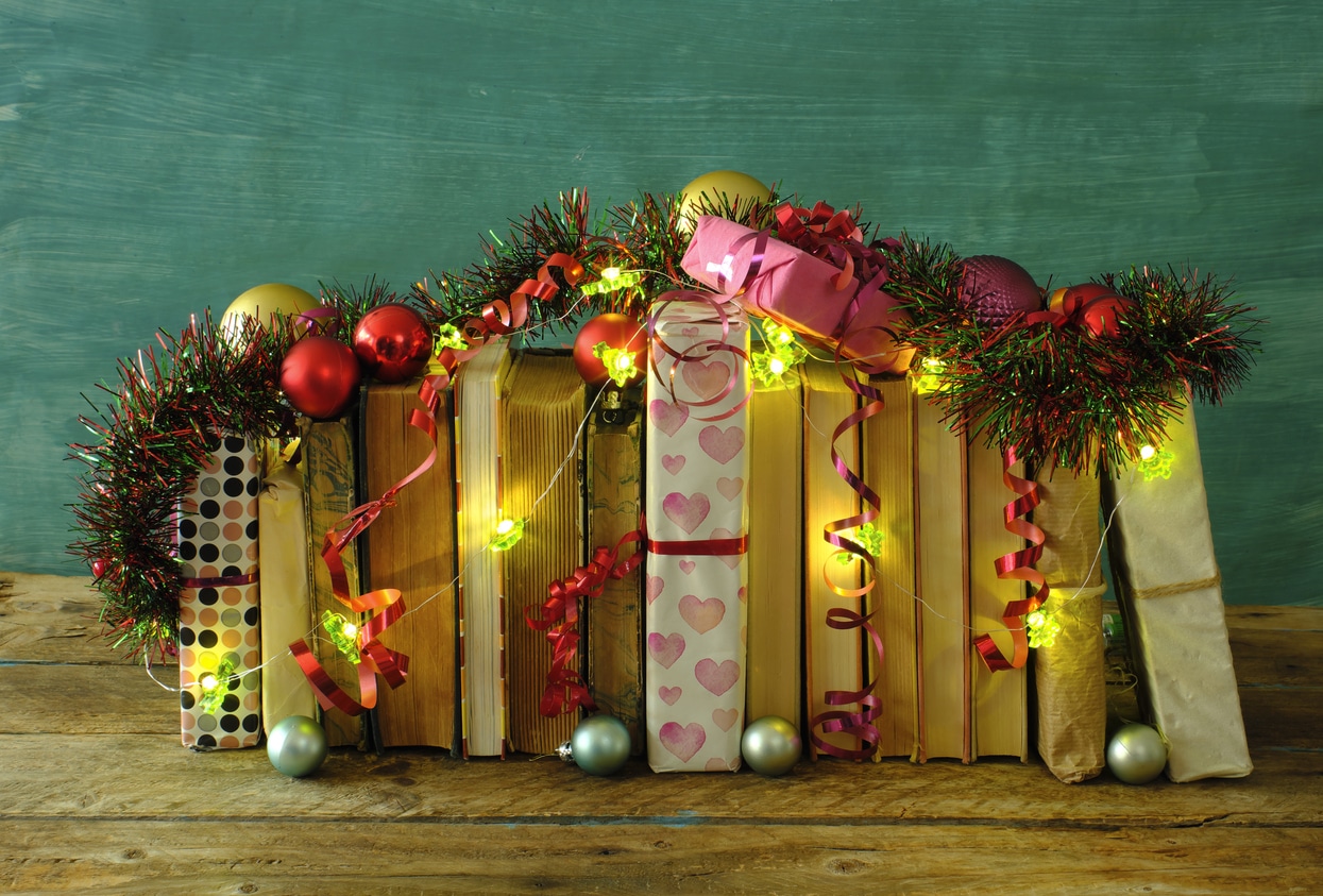 Rangée de livres décorés avec lumière, guirlandes et boules de Noël