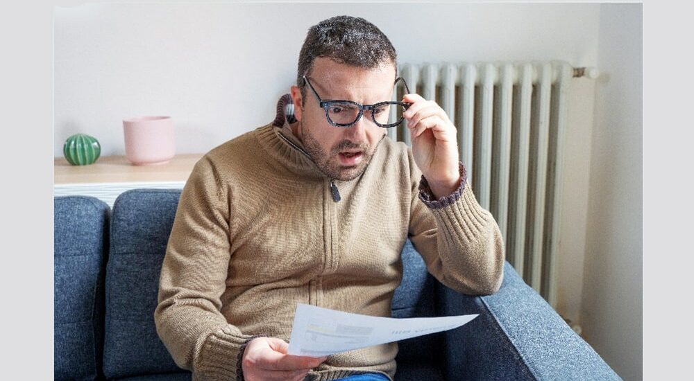 homme choqué en lisant un document