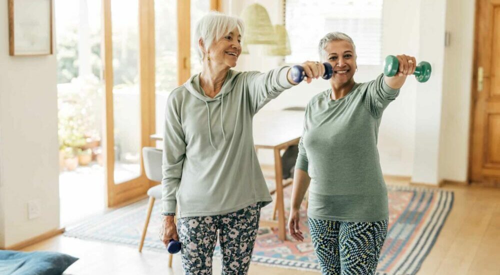 Deux femmes d'âge mûr pratiquant une activité physique à la maison