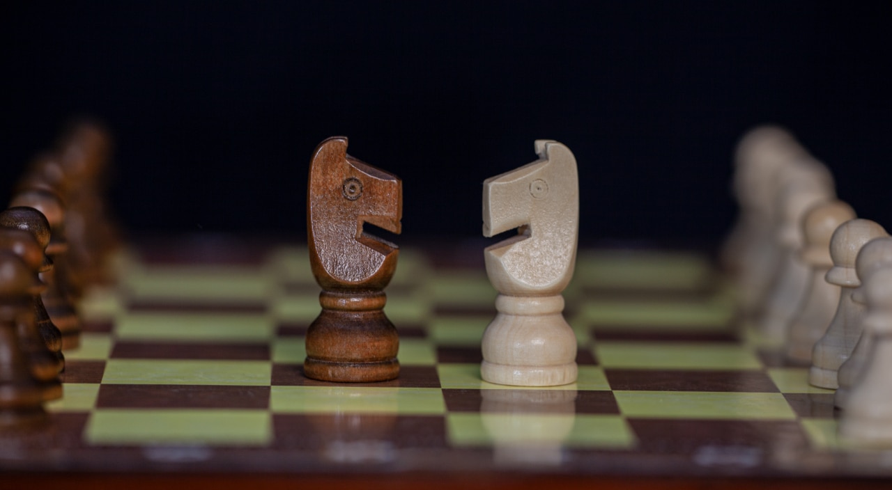 Deux cavaliers d'un échiquier se font face.